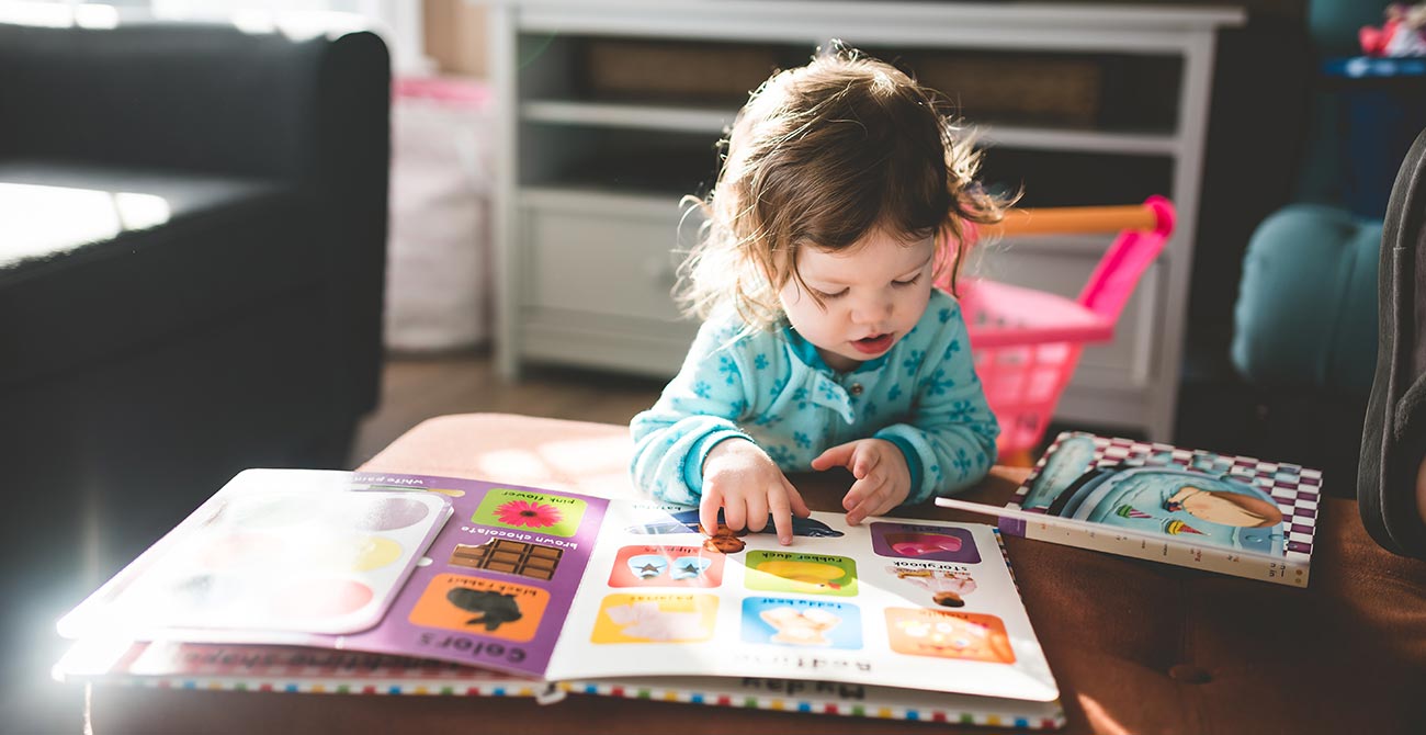 Kid reading a book at REACH Behavior and Development Center